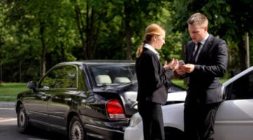 Man and woman drivers arguing after a car accident