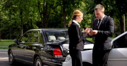 Man and woman drivers arguing after a car accident