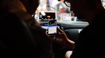 Photo by Rachel Claire: https://www.pexels.com/photo/a-person-holding-a-mobile-phone-inside-the-taxi-7263902/