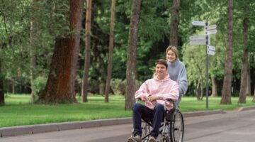 Photo by SHVETS production: https://www.pexels.com/photo/woman-pushing-the-wheelchair-with-a-man-8415730/