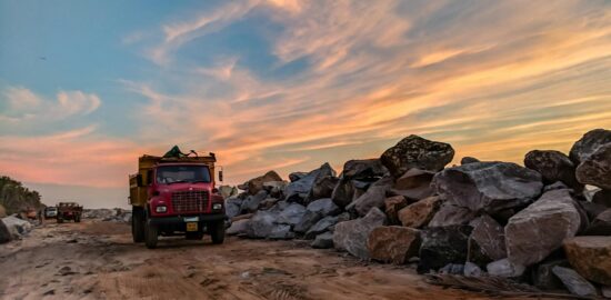 Photo by Guduru Ajay bhargav: https://www.pexels.com/photo/red-dump-truck-near-filed-rocks-under-cloudy-sky-1044290/